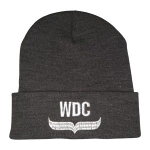 Charcoal grey knit beanie hat with Whale and Dolphin Conservation's logo. Hat made from made from Polylana®, a low-impact alternative to 100% acrylic and wool fiber using less energy, water and CO2 during production. Eco-friendly and warm.